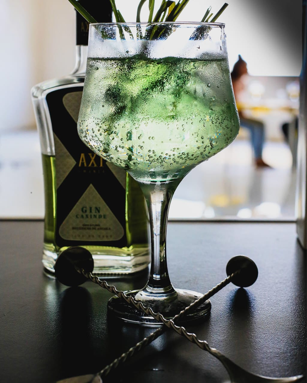 Gin Cocktail von Axi Gin Caxinde welche auf einem Bartisch serviert würde 
